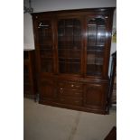 A reproduction oak bookcase, of nice quality having glazed top over drawer and cupboard base,