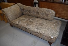 A 19th Century chaise longue, possibly later upholstery on turned mahogany legs, brass casters