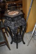 A late 19th or early 20th Chinese hardwood plant stand, extensively carved, with rouge marble inset,