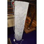 A modern floor standing lamp of moulded plastic form in opaque floral design