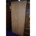 A modern pine effect wardrobe having carved double doors W73cm x H180cm x D51cm