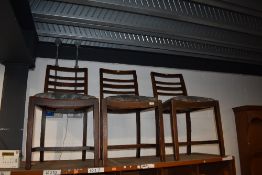 A set of three early 20th Century stained frame rail back dining chairs