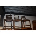 A set of three early 20th Century stained frame rail back dining chairs
