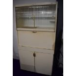 A vintage kitchenette, labelled Eastham, sliding glazed doors to upper section, central servery with