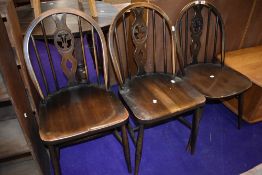 Three vintage dark stained Ercol Fleur de lys style dining chairs