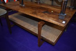 A 1970s teak coffee table having teak undertier