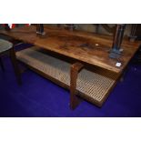 A 1970s teak coffee table having teak undertier