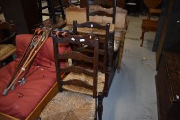 Three 19th Century oak ladder back chairs having rush seats