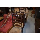 Three 19th Century oak ladder back chairs having rush seats