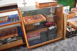 A vintage wood and glass display cabinet having three glass shelves with mirror base