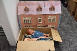 A modern wooden two storey dolls house having plastic and wooden furniture and accessories along