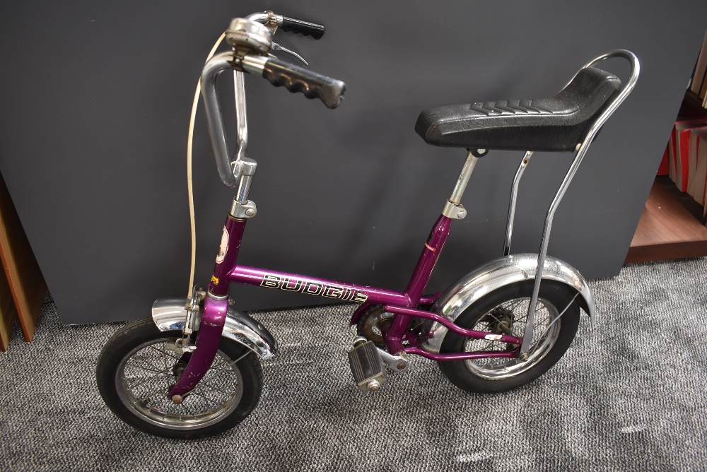A 1970's Raleigh Budgie Child's Bike in purple with black seat, chrome mud guards, metal spoked