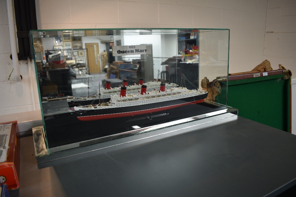 A plastic scale model of RMS Queen in glass display case with mirrored back, case size length