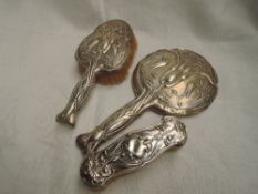 An Edwardian silver backed hand mirror and brush having Art Nouveau style stork and water lily