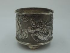 An early 20th Century Chinese silver salt having repousse dancing dragon decoration with plain