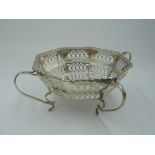 A silver bon bon dish of octagonal form having pierced decoration and four loop handled feet,