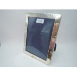 A silver photograph frame of plain rectangular form having blue velvet easel back, London 1992,