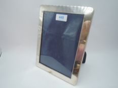 A silver photograph frame of plain rectangular form having blue velvet easel back, London 1992,