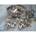 A large silver plated punch bowl having scroll decoration and plain cartouche, with six punch