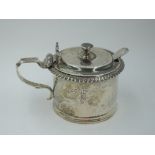 A Victorian silver mustard pot of plain cylindrical form having gadrooned rim and scallop shell