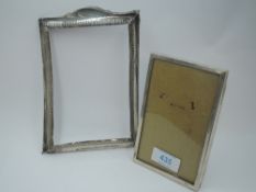 A small silver photograph frame of plain rectangular form having wooden back with easel stand,