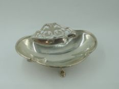 An Edwardian footed bonbon dish having trefoil scallop and paw feet, pierced handle and shaped