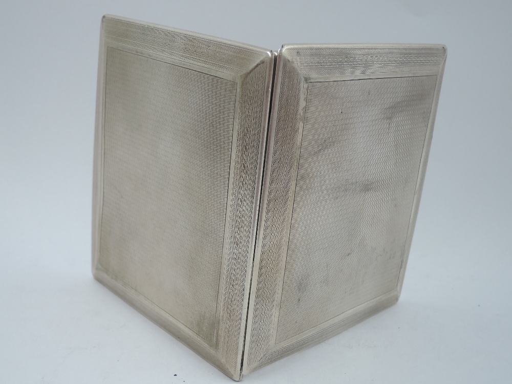 An Art Deco style silver slide action cigarette case having engine turned decoration with Greek