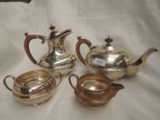 A four piece silver tea set of plain waisted circular form having fruit wood handles and knops,