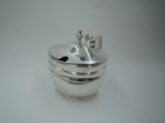 A Georgian silver mustard pot of plain oval form having reeded rim, hinged lid with thumb rest and