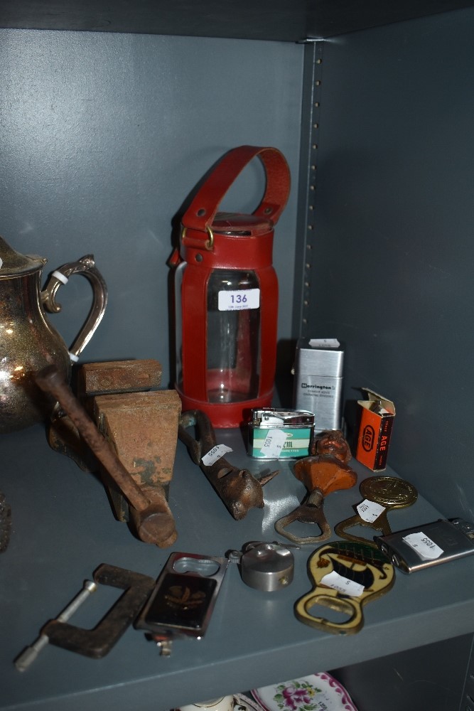 A mixed lot of items including vintage bottle openers, a vice, lighters and more.