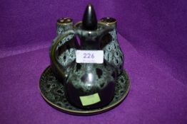 A ceramic sauce or cruet set with green glaze