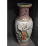 A large standing Cantonese styled floor vase having peacock enamel scene and standing at 60cm tall