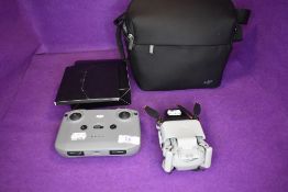A DJI drone camera with bag and accessories.
