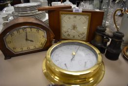 Two vintage mantle clocks a set of binoculars and barometer.