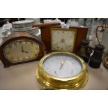 Two vintage mantle clocks a set of binoculars and barometer.