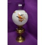 A vintage brass bodied oil burning lamp with game bird and pheasant design shade