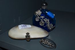 A vintage shell purse, a silver tone foxglove brooch and a perfume bottle.