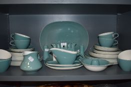 A good quantity of vintage Poole pottery table ware including toast rack, salt and pepper pots, jug,