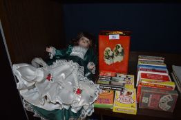 A good quantity of packs of playing cards a vintage tin and a doll.