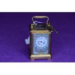 A miniature brass carriage clock,probably 19th century French,having hand painted countryside and