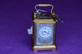 A miniature brass carriage clock,probably 19th century French,having hand painted countryside and