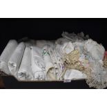A box full of vintage and antique table linen and similar including damask table cloths and more.