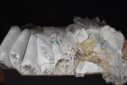 A box full of vintage and antique table linen and similar including damask table cloths and more.