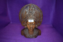 An intricately carved ethnic styled wooden bust.