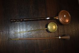 A copper post horn and two chestnut roasters one brass and one traditional copper