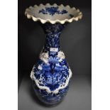 A large standing blue and white wear Chinese vase having raised dragon motif and scalloped rim