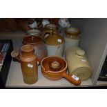 A selection of earthen ware salt glazed jugs and flagons including spouted lidded pot