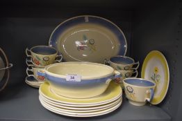 A collection of Susie cooper plates,soup mugs and platters having cream ground with blue border