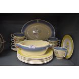 A collection of Susie cooper plates,soup mugs and platters having cream ground with blue border