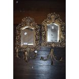 Two antique bevelled glass mirrors having filigree gilt edging and integrated candlestick holders.
